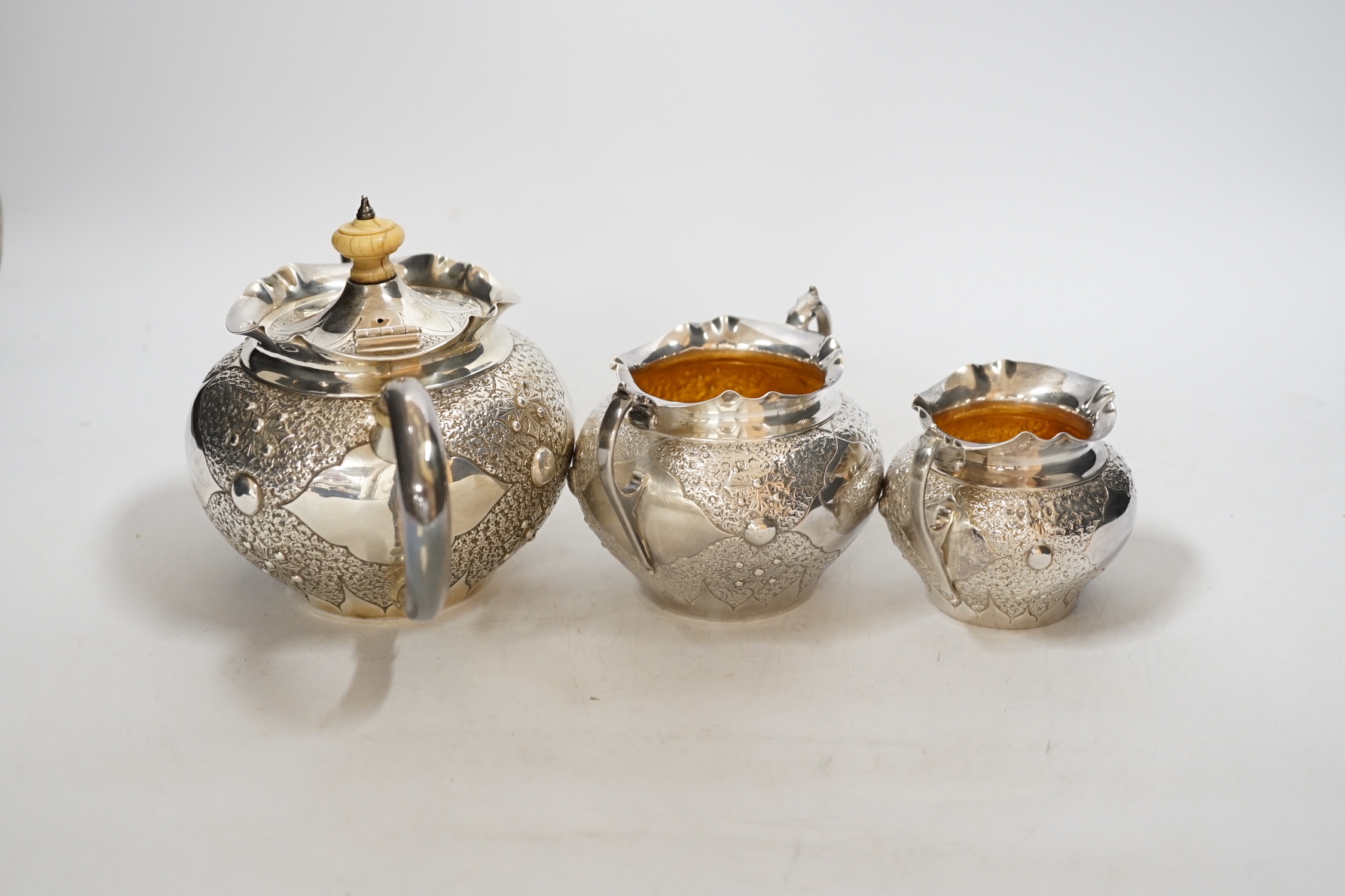 A Victorian embossed silver three piece bachelors tea set, Charles Edwards, London, 1880, gross weight 17.9oz., CITES Submission reference WAD4FJG4